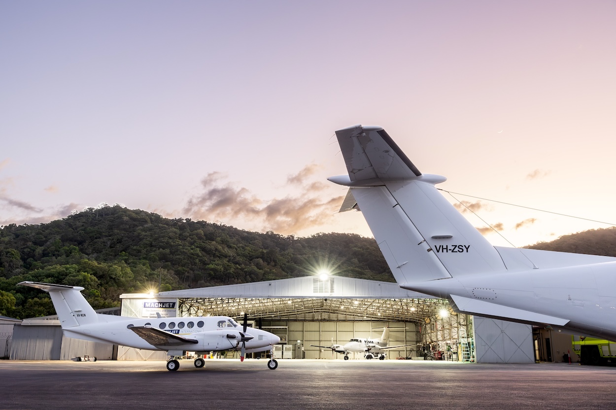 Machjet International King Air outside the lit Hangar 9 at the Cairns FBO at twilight